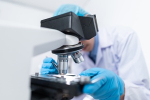 Photo d'un chercheur qui regarde à travers un microscope. 
