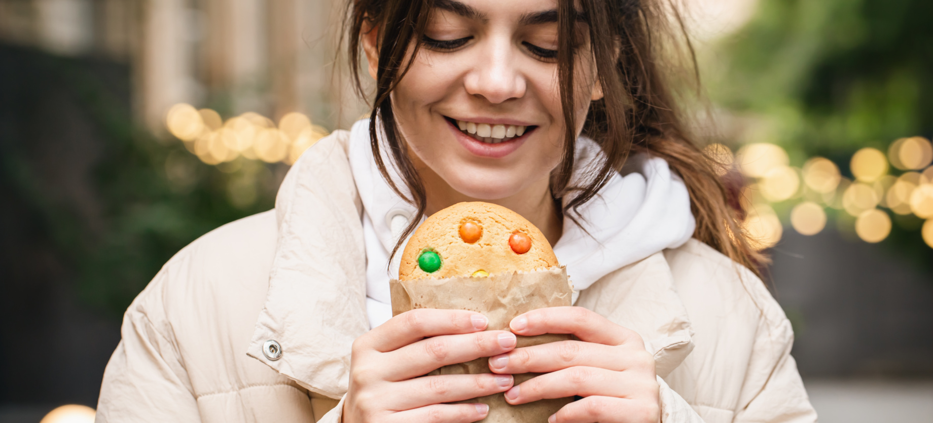 Attractive young woman with a beautiful gingerbread on a walk.