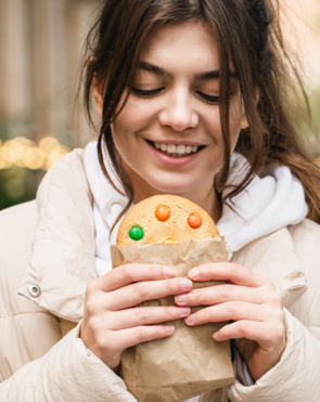 Attractive young woman with a beautiful gingerbread on a walk.