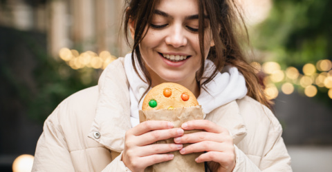 Attractive young woman with a beautiful gingerbread on a walk.